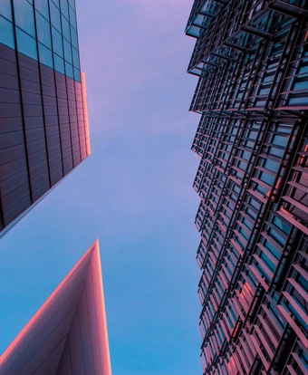 A modern architectural structure with geometric patterns, vibrant colors, and a striking triangular design against a hazy sky, suggesting growth opportunities