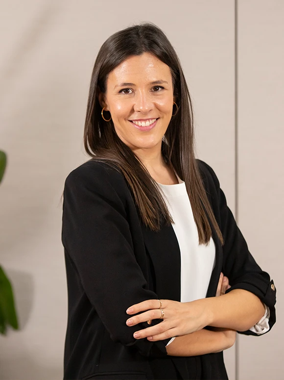 The image shows Beatriz Tornero, a smiling woman with long dark hair wearing a black blazer, posing in a professional setting