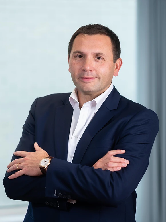 Salvatore Ruocco, a professional businessman wearing a navy blue suit, standing with his arms crossed and a confident expression