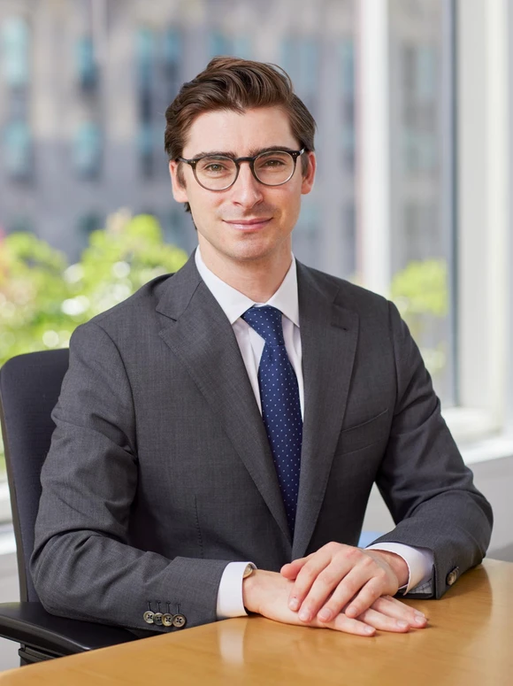 Judd Liebman, a professional-looking businessman in a suit and tie, sits at a desk in front of a glass wall, with a serious expression on his face