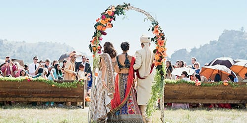 A wedding taking place outside with a flower arrangement.