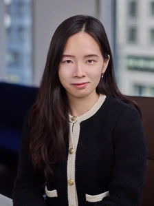 The image shows a headshot of Winnie Cho, a young Asian woman with long dark hair wearing a black and white sweater against a blurred background