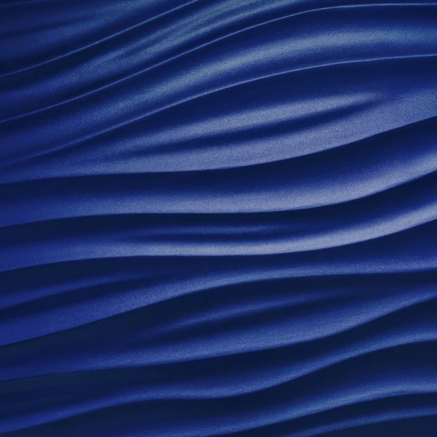 The image shows a close-up view of a dark blue satin or silk fabric with flowing, wavy patterns and creases