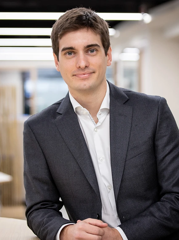 Guillermo Felez, a man in a dark suit, standing with a confident expression in what appears to be a professional setting