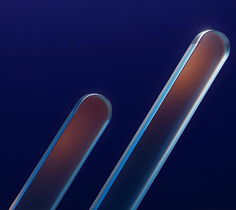 The image shows two elongated, reflective metal bars against a deep blue background, creating an abstract, futuristic composition