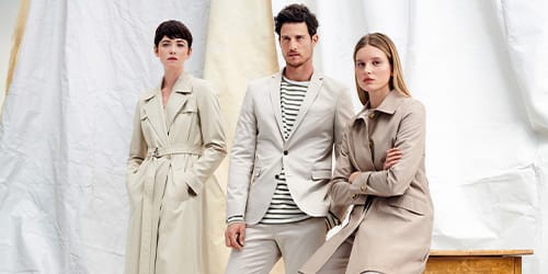 Three models dressed in beige looking at the camera