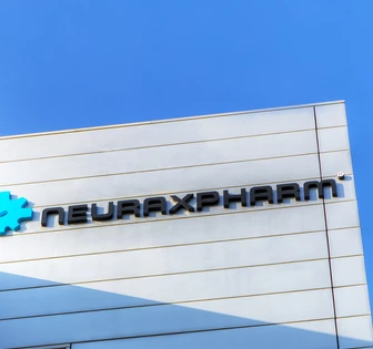 The image shows the signage for Neuraxpharm, a pharmaceutical company, against a bright blue sky