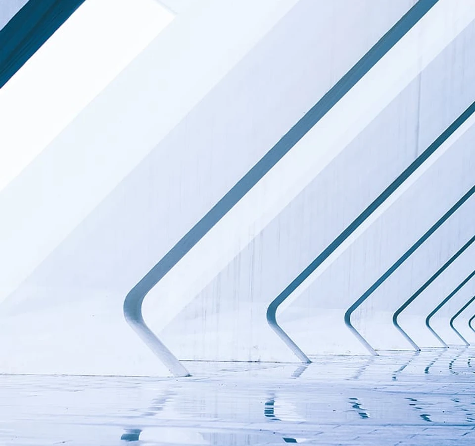 The image shows a reflection of a modern architectural structure with angular, glass-enclosed walkways leading to a body of water