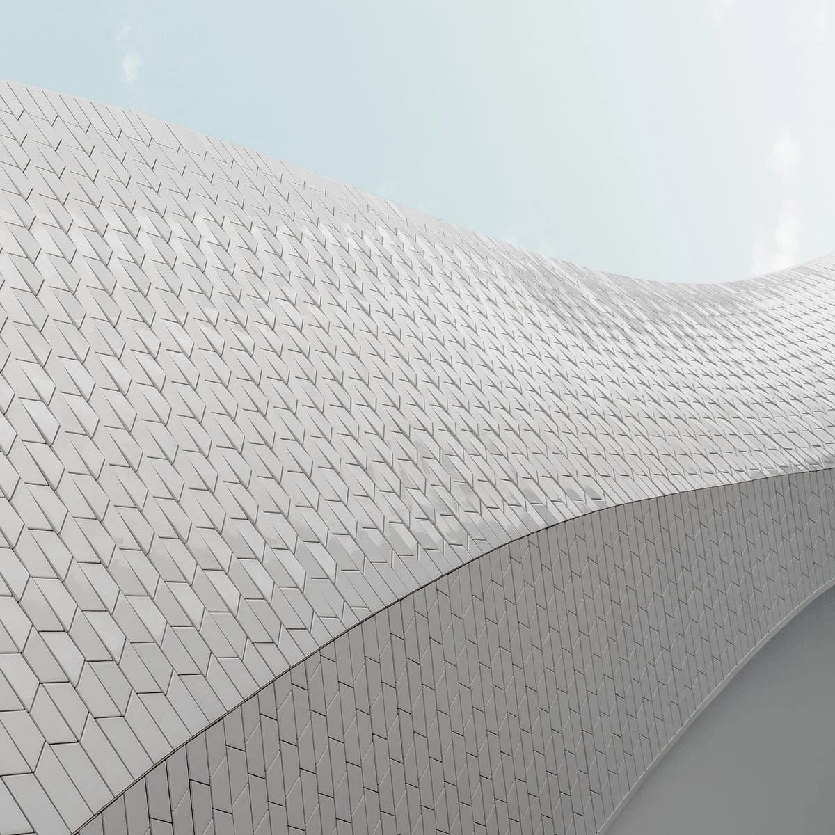 A large, angular white structure with a repeating pattern of diamond-shaped panels spanning across the frame, against a pale blue sky