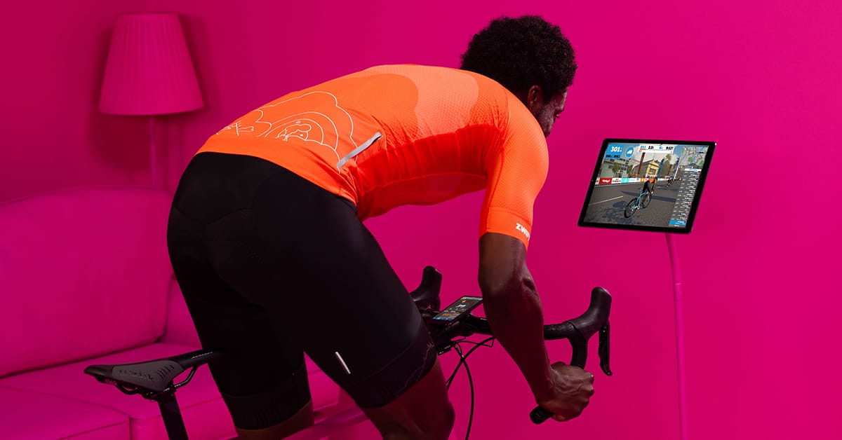 A man spinning on an electrical bike with a screen.